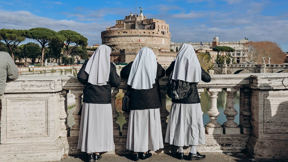 Nuns on the Ponte Vittorio Emanuele II look at Rome and Castel Angelo