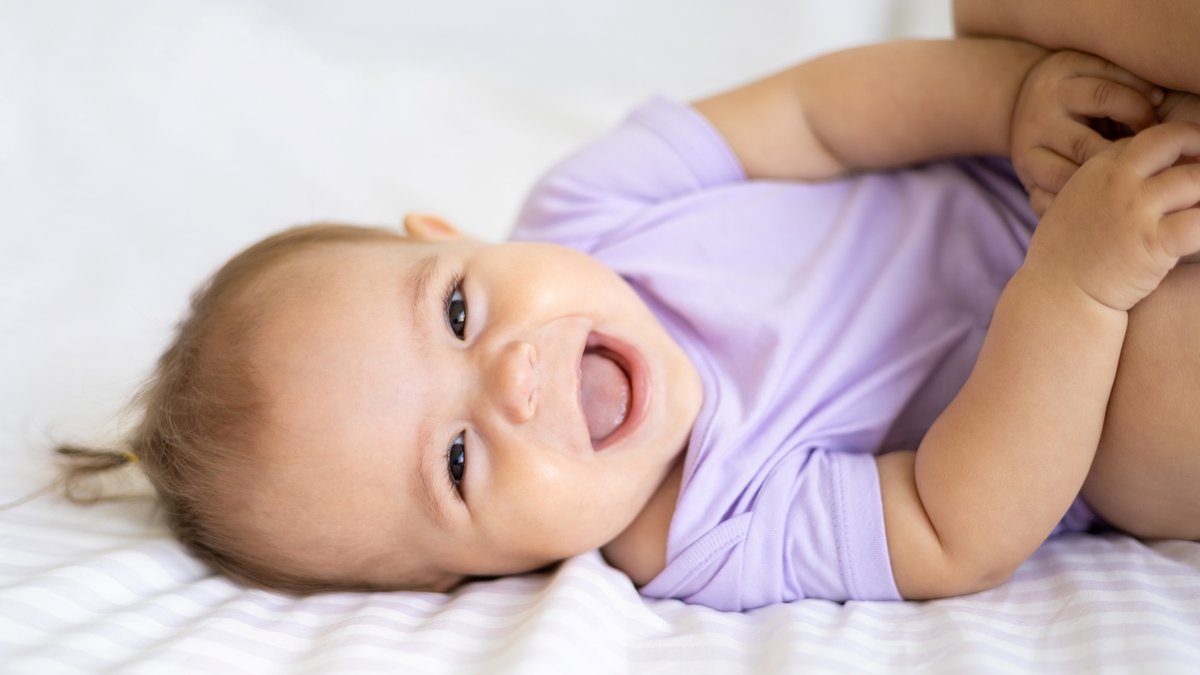 Smiling newborn girl in purple outfit