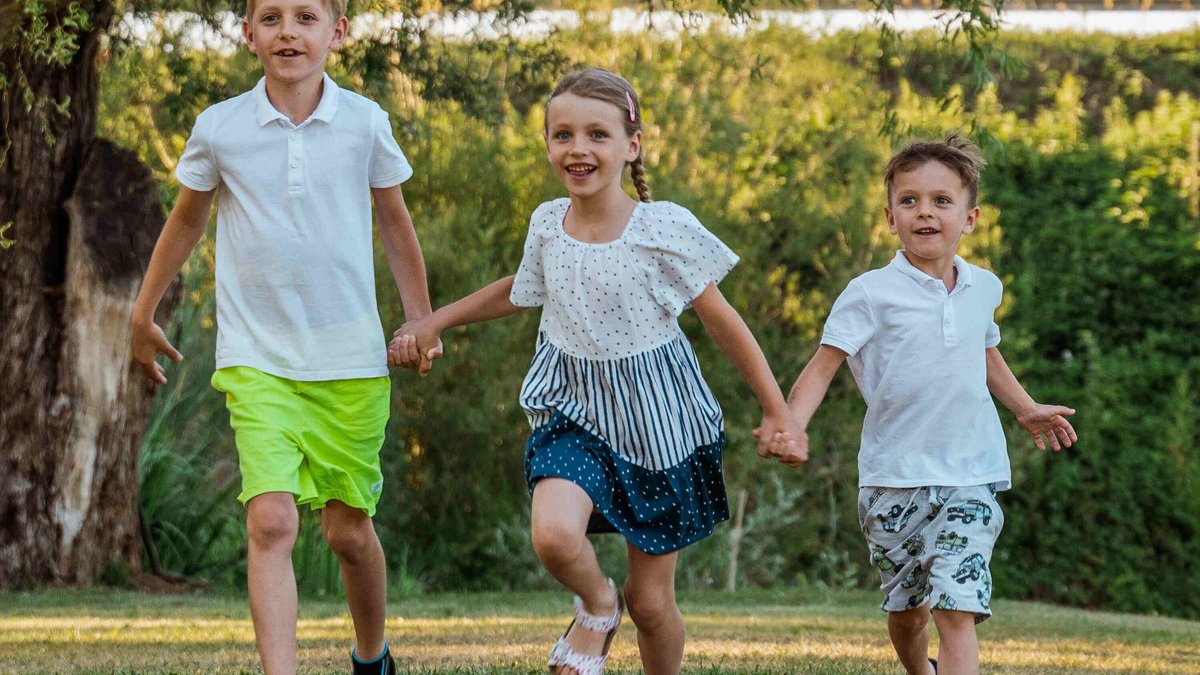 Three children running outside