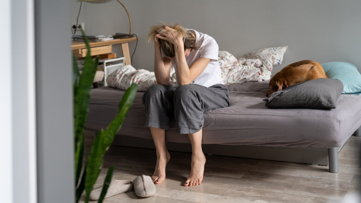 Desperate woman sitting on bed