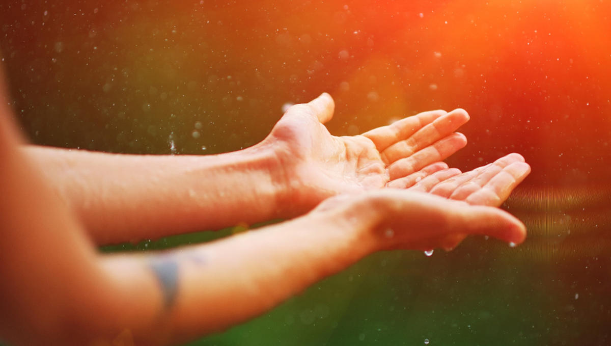 Womans hand catch rain drops