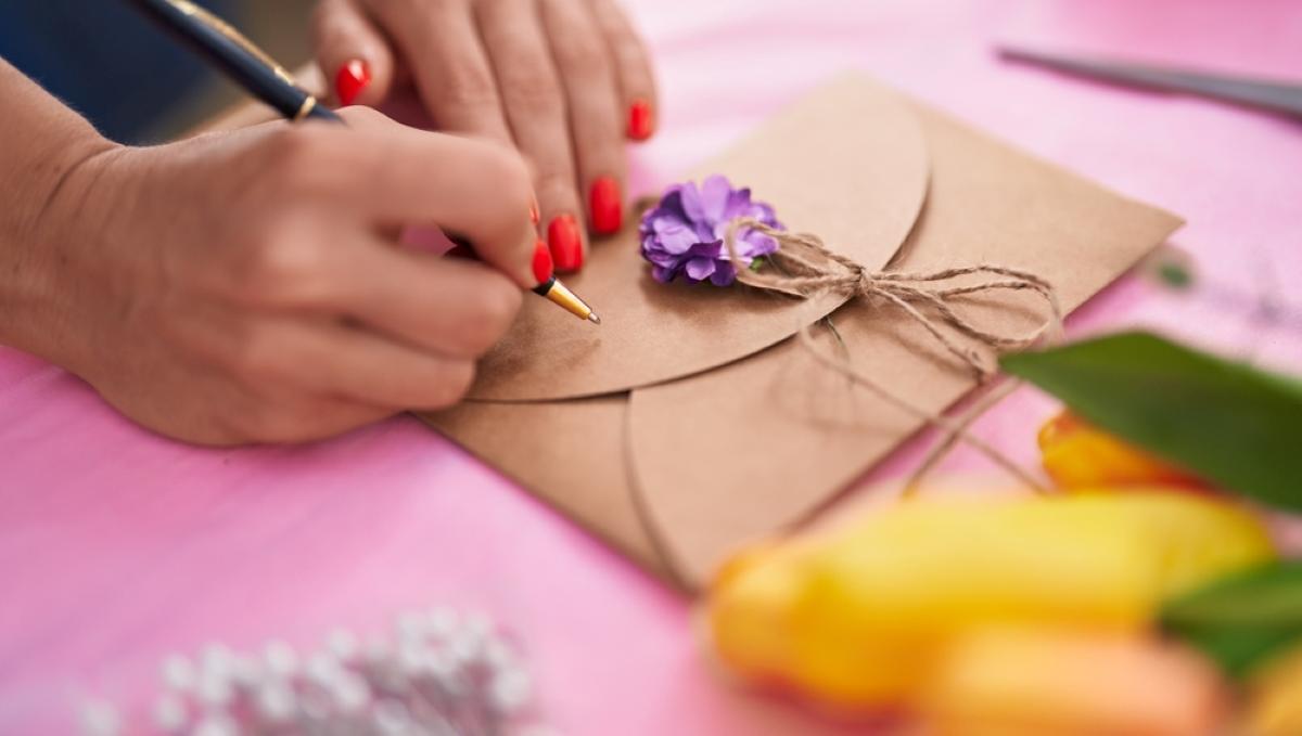 young blonde woman florist writting on envelope letter at florist store