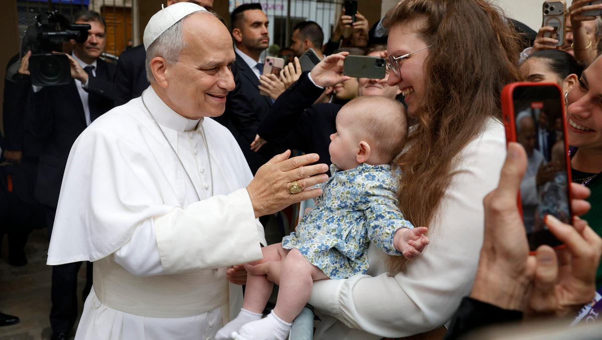 Pope Leo XIV (L) blesses six-months old baby Sophia and her mother Alessia Premru (R) as he leaves the Catholic Institute