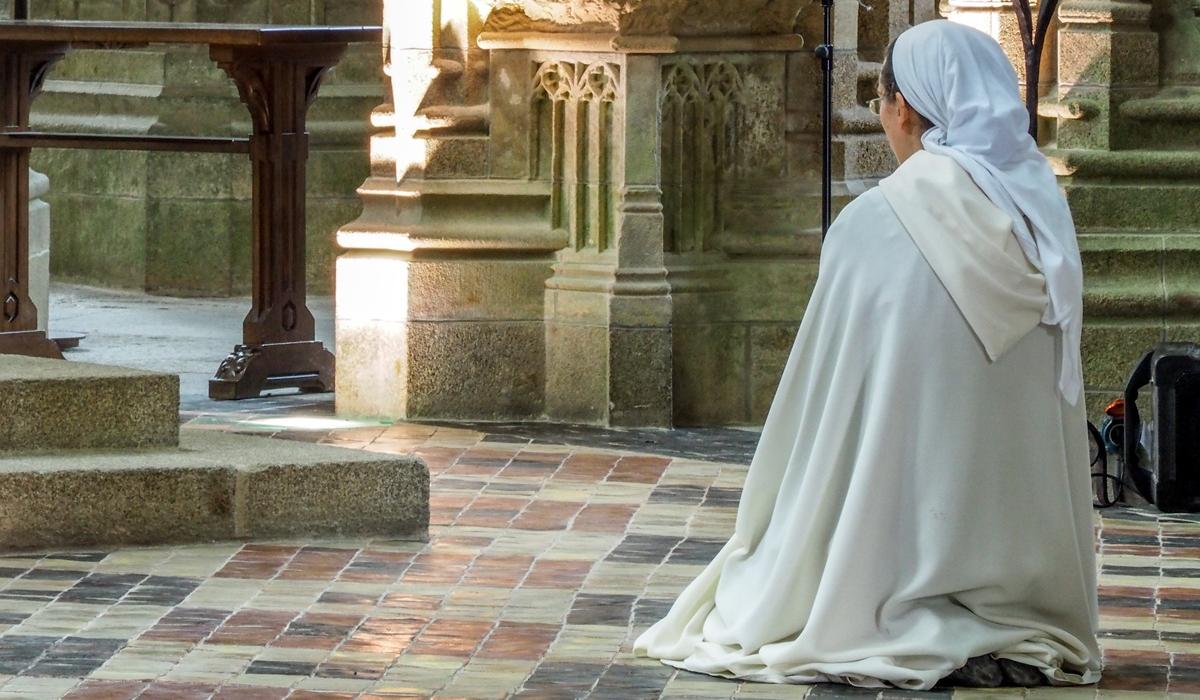 nun kneeling in prayer