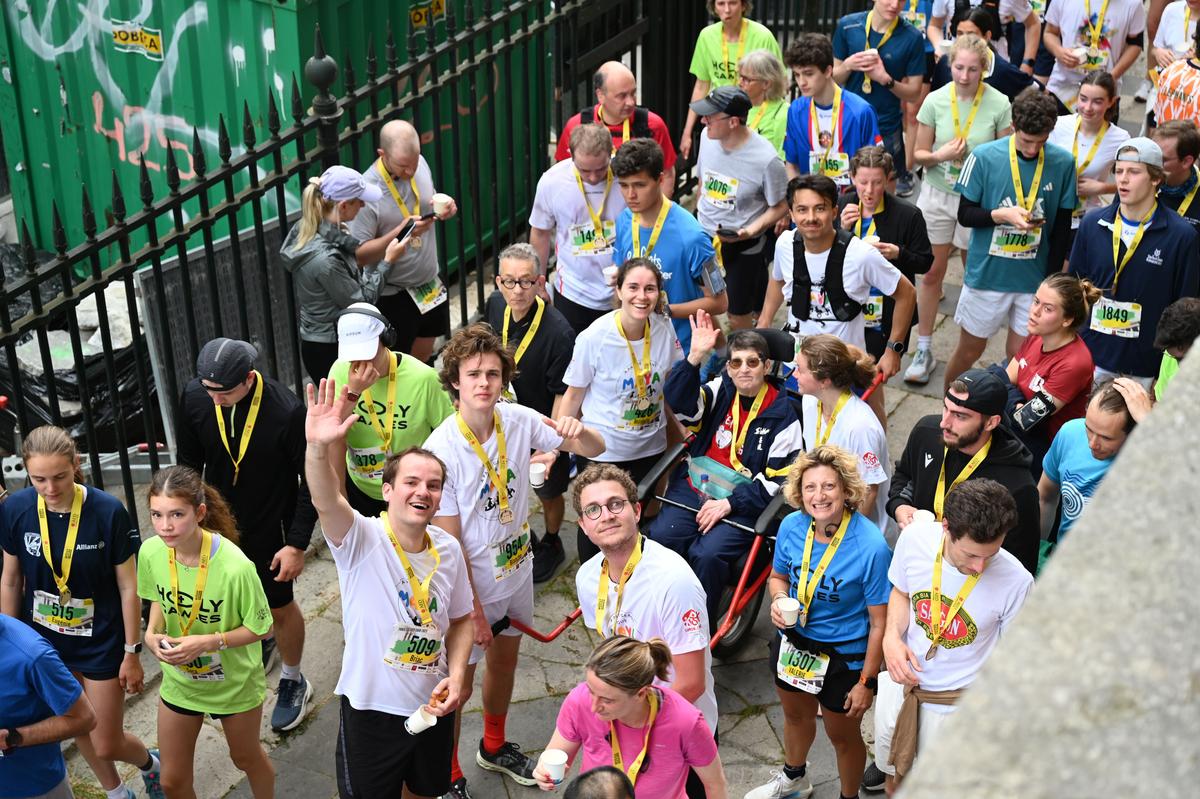 Des coureurs portent une joëlette pour l'association "À pas de géant pour Maya" lors du Paris Eglises Tour 2025.
