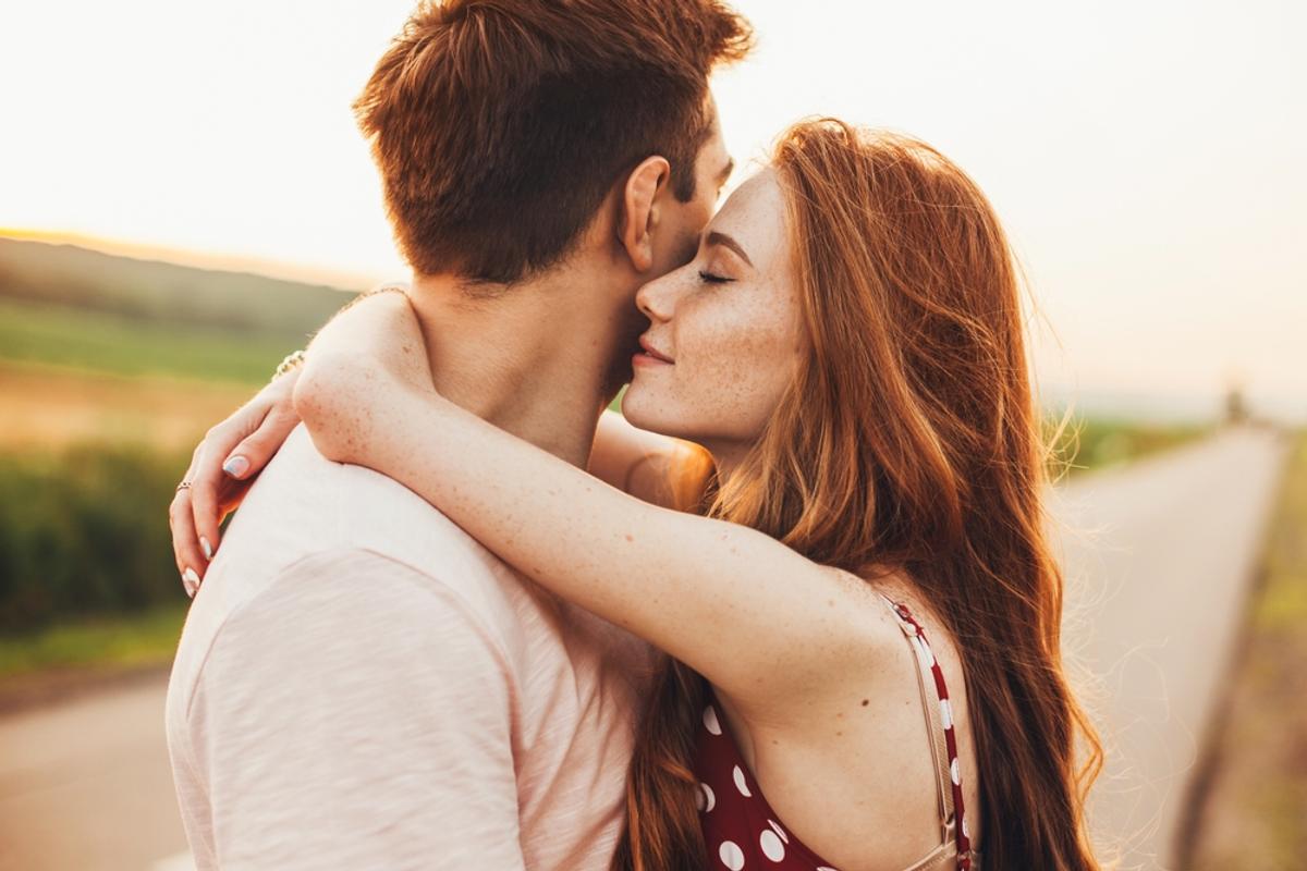 Close-up portrait of a caucasian young loving couple embracing while standing on a roadside. Couple embracing road travel. Sunset scene. | date,romance,couple,caucasian,happy,enjoying,spouse,smile,road,kissing,embracing,season,female,smiling,wife,dates,enjoyment,ginger,person,looking,autumn,adult,love,handsome,woman,weekend,cute,two,fall,romantic,street,walking,man,relationship,together,lovely,break,nature,valentine,portrait,lifestyle,afternoon,standing,sunlight,outdoors,authentic,hug,family,posing,walk