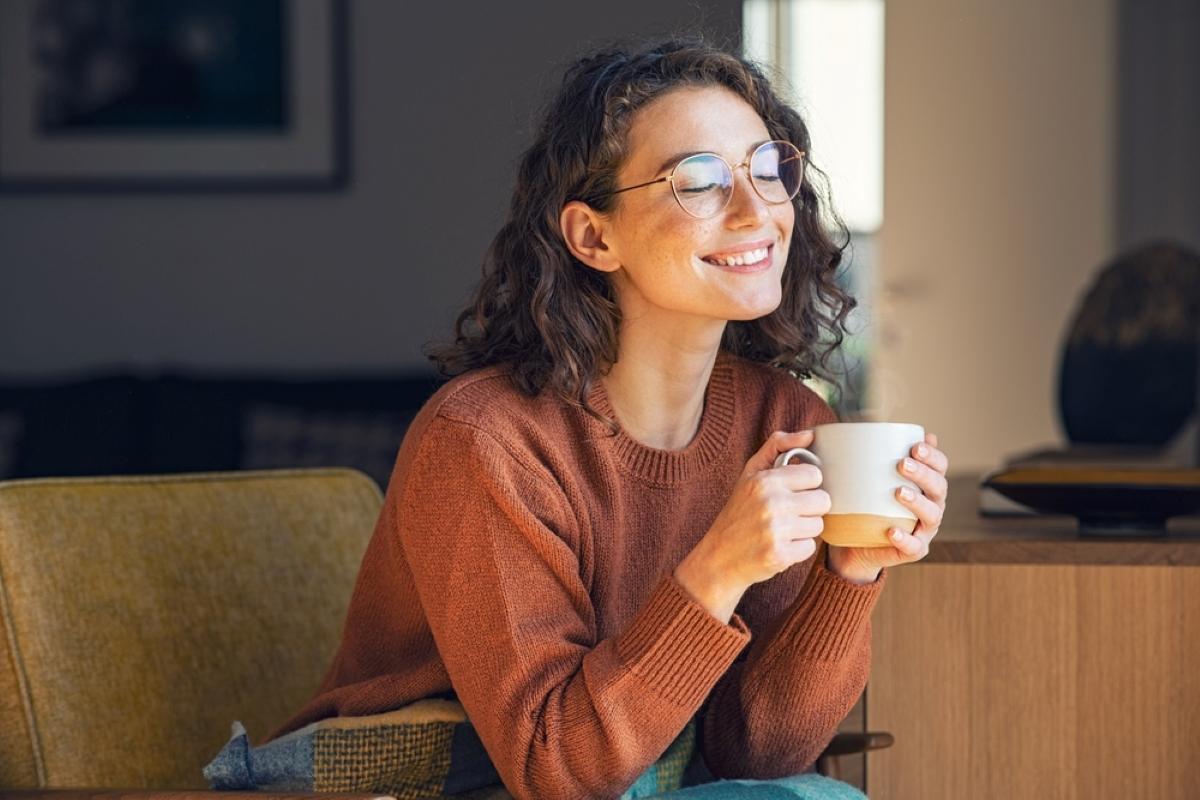 Happy young woman drinking a cup of tea