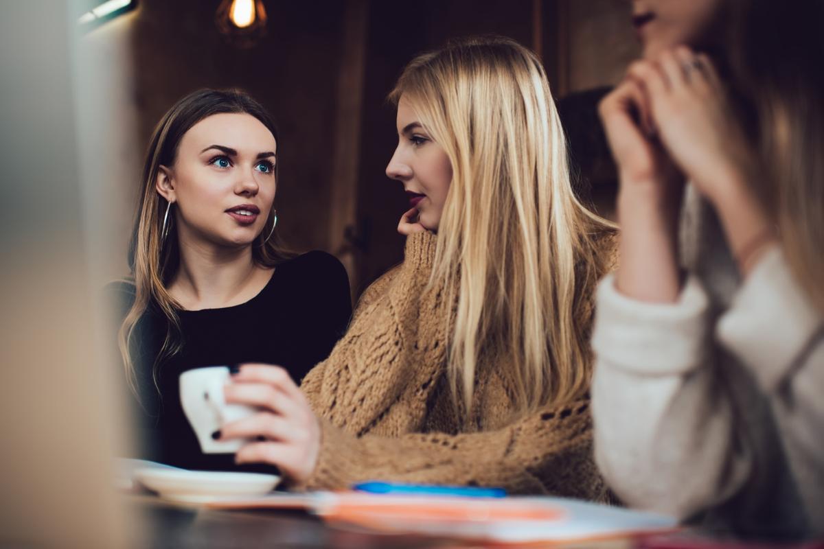 Trzy przyjaciółki rozmawiają w kawiarni
