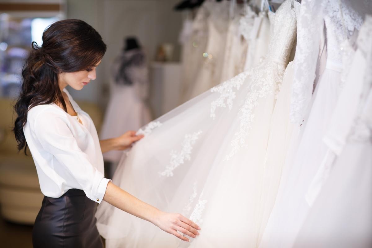 dealer consultant in the background of wedding dresses