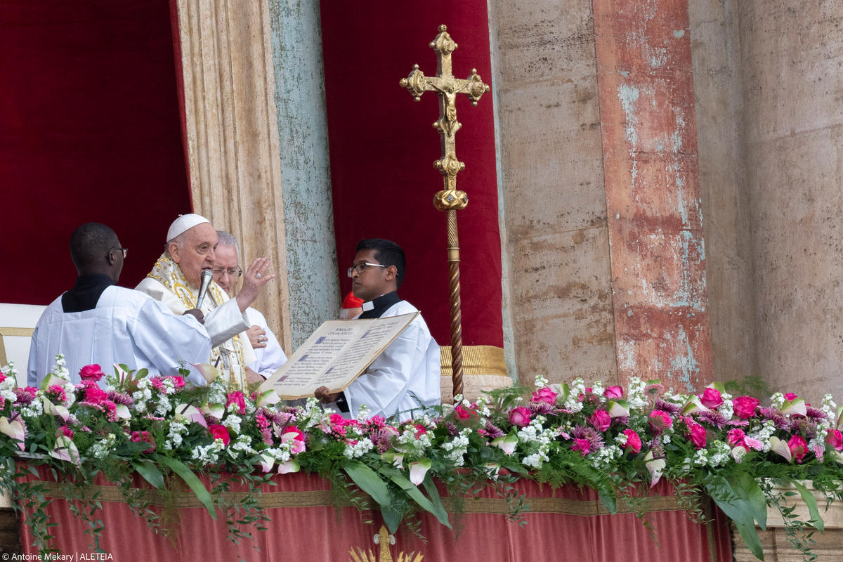 Pope Francis waves from the central loggia of St. Peter's basilica during the Easter 'Urbi et Orbi' message and blessing to the City and the World as part of the Holy Week celebrations