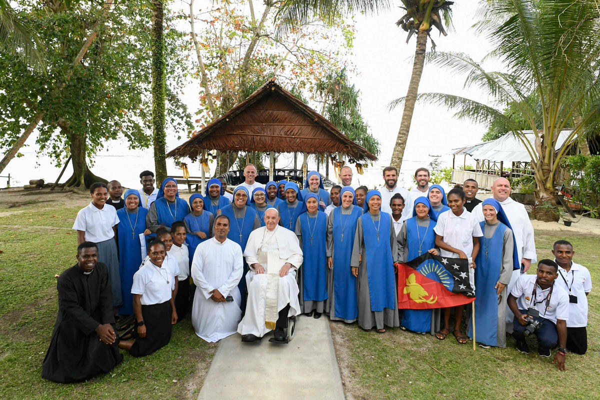 Pope Francis posing for a group photo during a meeting with missionaries at the Holy Trinity Humanities School in Baro, Papua New Guinea.