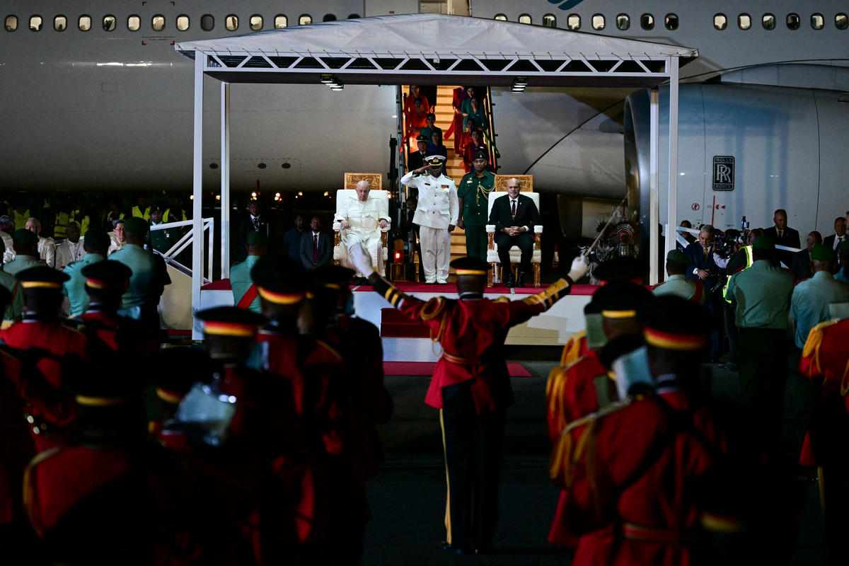 Pope Francis (L) takes part in a welcome ceremony with Papua New Guinea's Deputy Prime Minister John Rosso (R) upon arrival at the Port Moresby International airport on September 6, 2024.