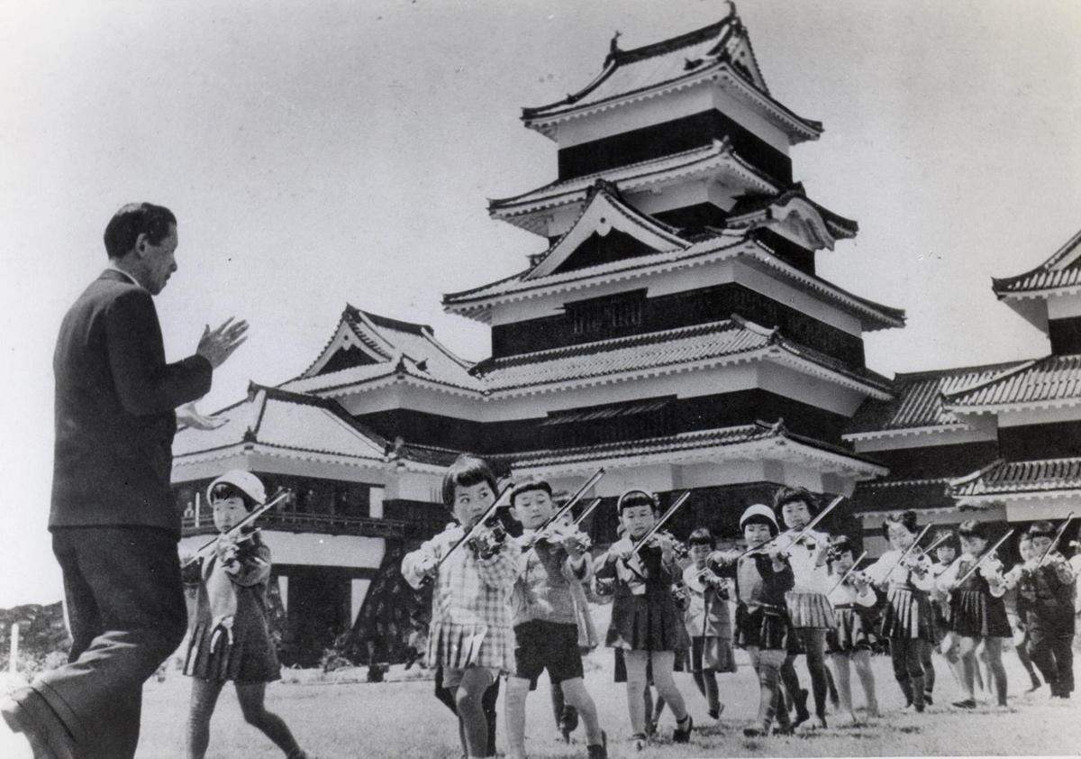 Shinichi Suzuki gives a music lesson outside Matsumoto Castle in Japan