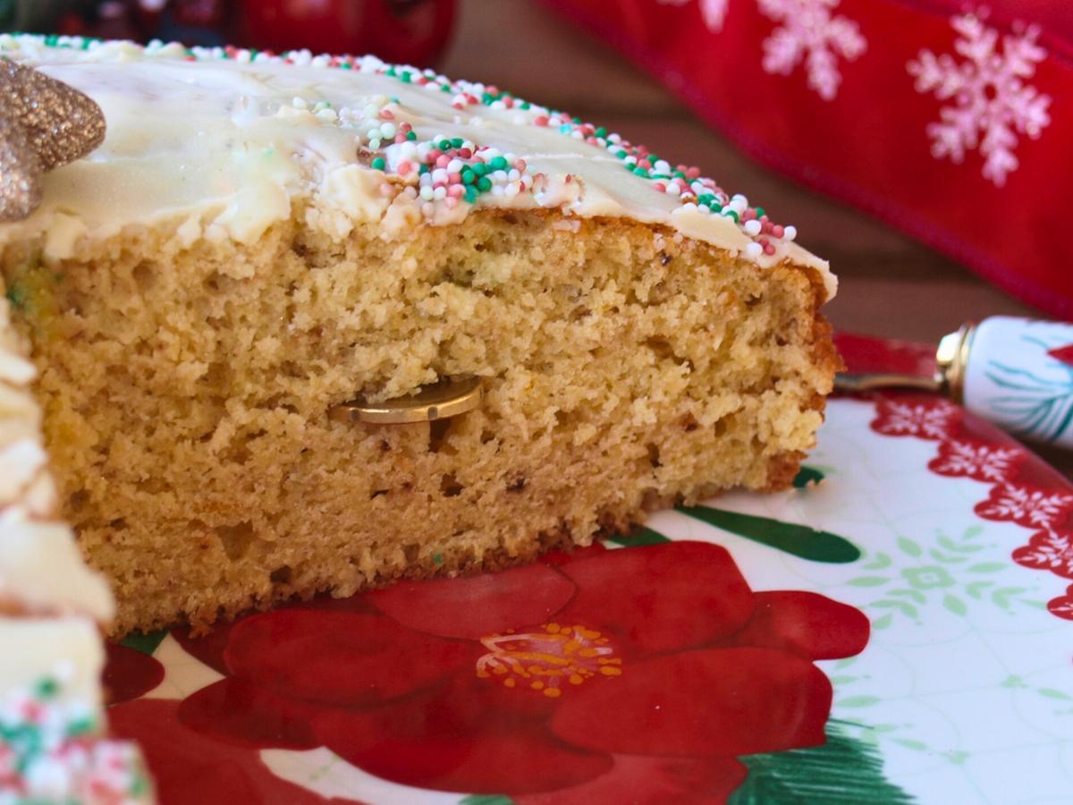 Close up of Greek Vasilopita (the Greek lucky new year’s cake) covered in white chocolate icing and decorated with sugar sprinkles
