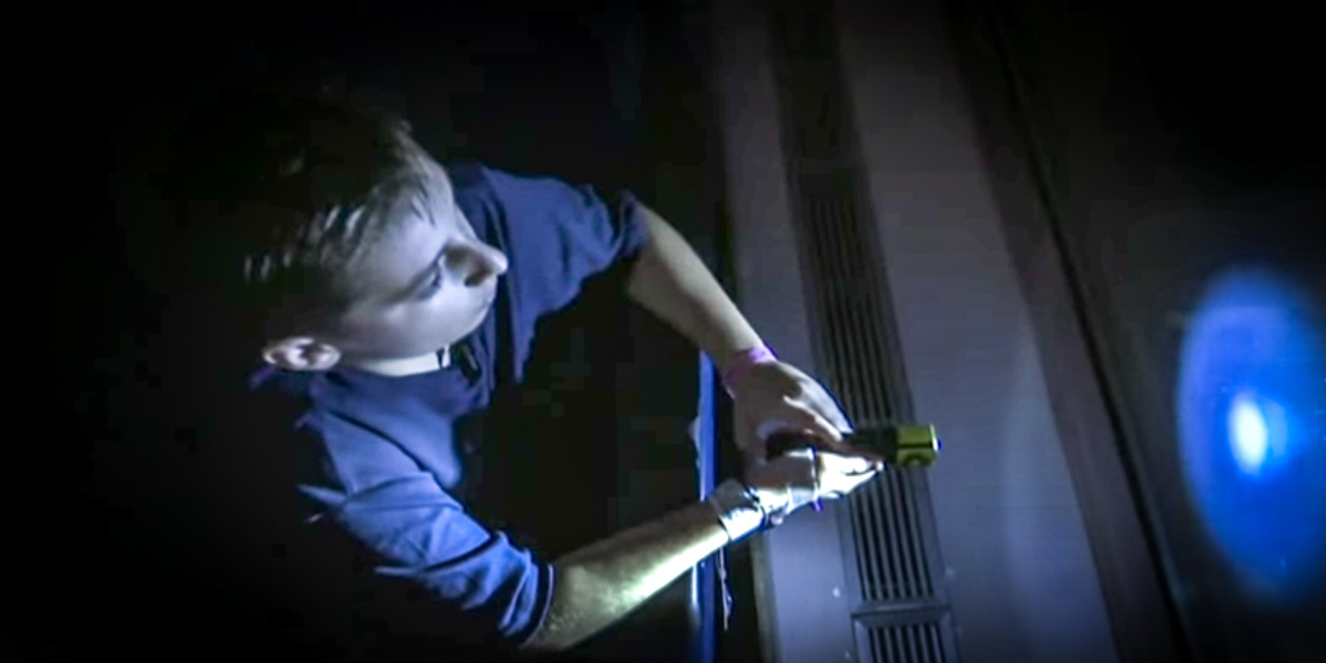 BOY SHINING LIGHT IN WINDOW