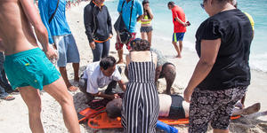 Beachgoers form human chain to save drowning family