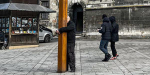 Viral photo of elderly man hugging life-sized crucifix in Ukraine moves hearts around the world