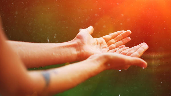 Womans hand catch rain drops