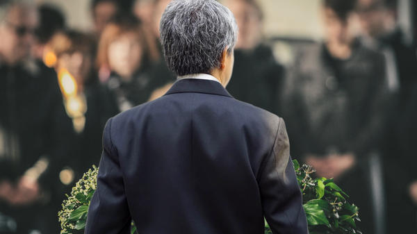Man delivering a eulogy from behind