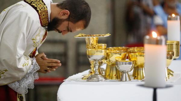 Ksiądz wykonuje głęboki skłon na Eucharystii