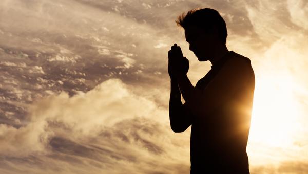 man praying looking at the sky