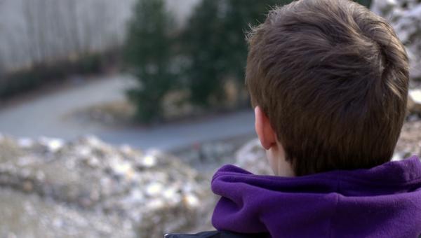 UN JEUNE HOMME REGARDE AU LOIN