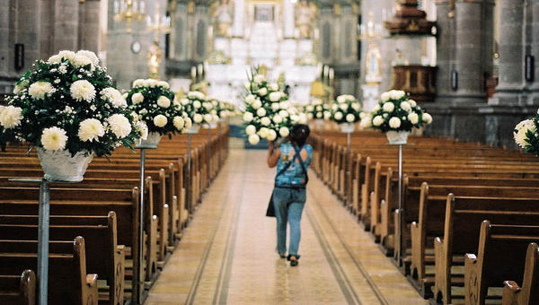 WOMAN DECORATING CHURCH WITH FLOWERS