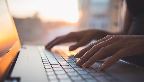 WOMAN TYPING LAPTOP