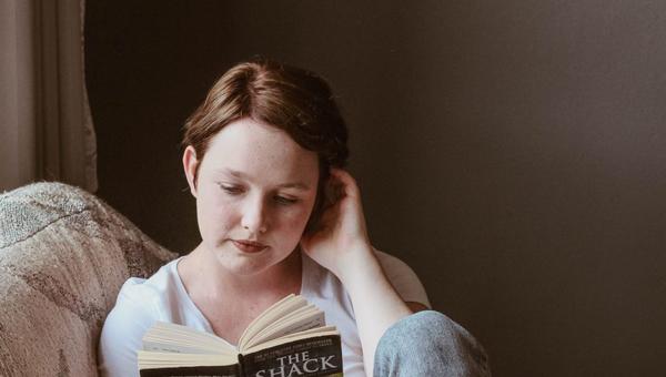 WOMAN, READING, SOFA