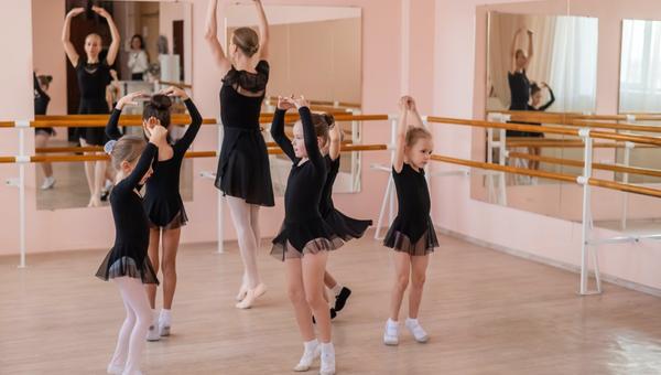 École de ballet pour enfants. Une femme caucasienne enseigne le ballet aux petites filles.