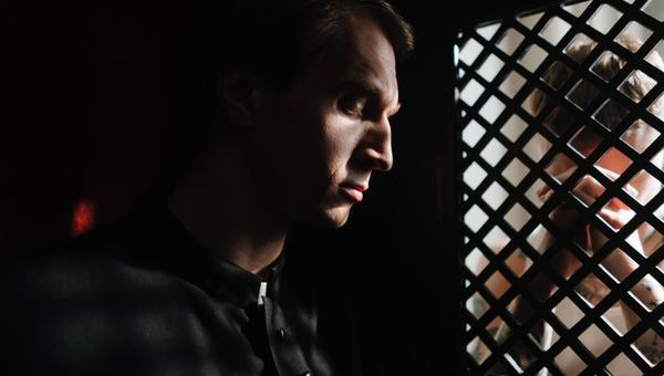 a priest listening to the person confessing