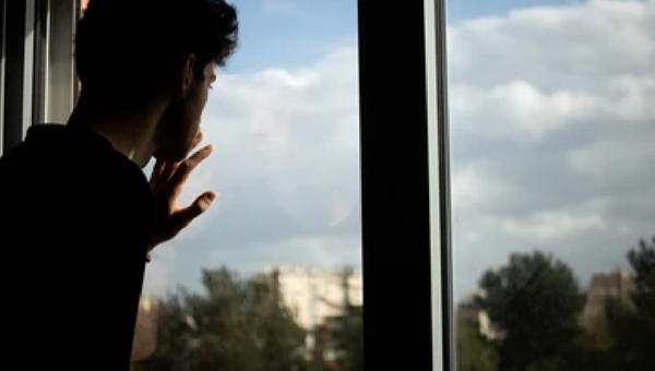 RAGAZZO DI SPALLE ALLA FINESTRA