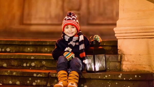 BAMBINO CON LANTERNA SU SCALE DI UNA CHIESA