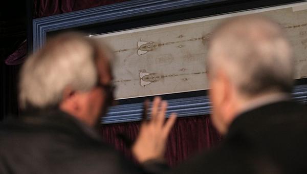 Dwóch mężczyzn ogląda Całun Turyński