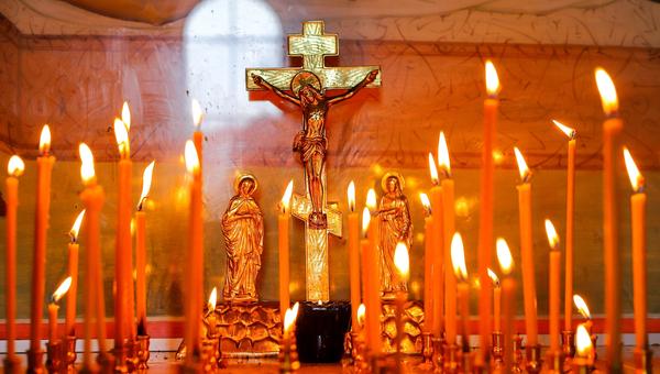 Krzyż prawosławny pośród świec