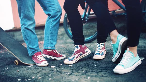 Close up of modern sneakers worn by friends