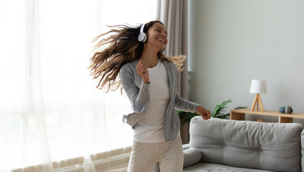 Woman dancing alone with headphones on