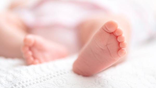 Newborn baby on a white blanket - tiny baby feet closeup