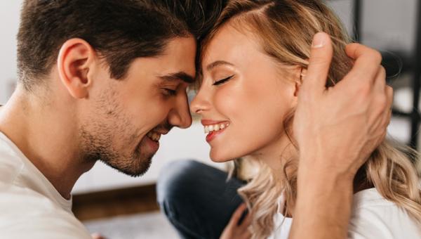 Portrait of two beautiful people in love smiling with closed eyes