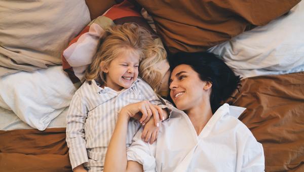 Mama z córką leżą w piżamach na kanapie