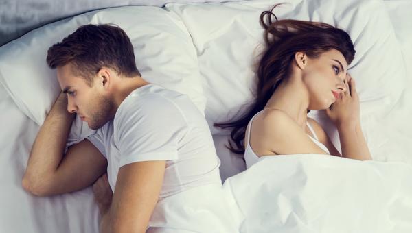 unhappy young couple on the bed in bedroom