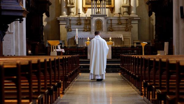 Priest in empty church