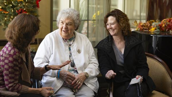 The Rosary Team members praying the rosary with an elder care patient