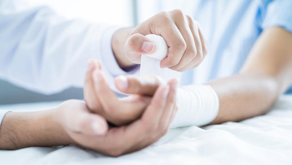 Médico fazendo curativo em paciente
