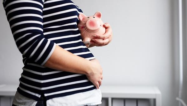 Pregnant woman with piggy bank