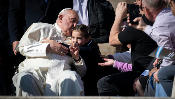 A young girl hugs Pope Francis at the conclusion of his general audience in St. Peter's Square, Vatican, October 30, 2024.