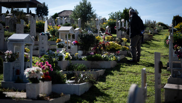 Praying in front of the graves of their departed loved ones.