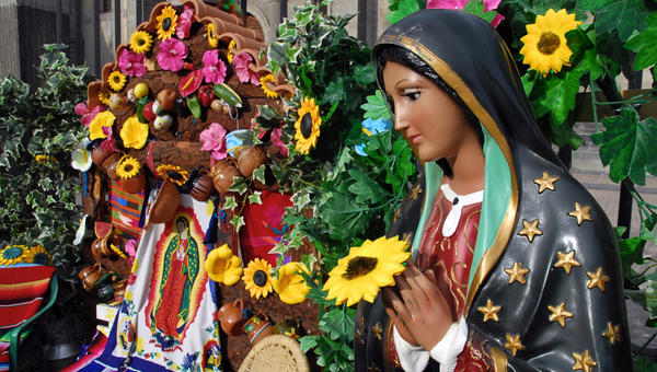 Statue of Our Lady of Guadalupe amid flowers