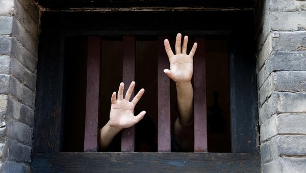 prisoner hands reach out from bars