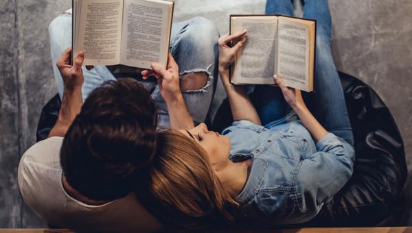 COUPLE READING NEXT TO EACH OTHER
